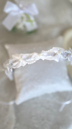 Kopfschmuck Kommunion: Detailaufnahme der Satinschleife mit Perle am weißen Kinder-Haarreif.