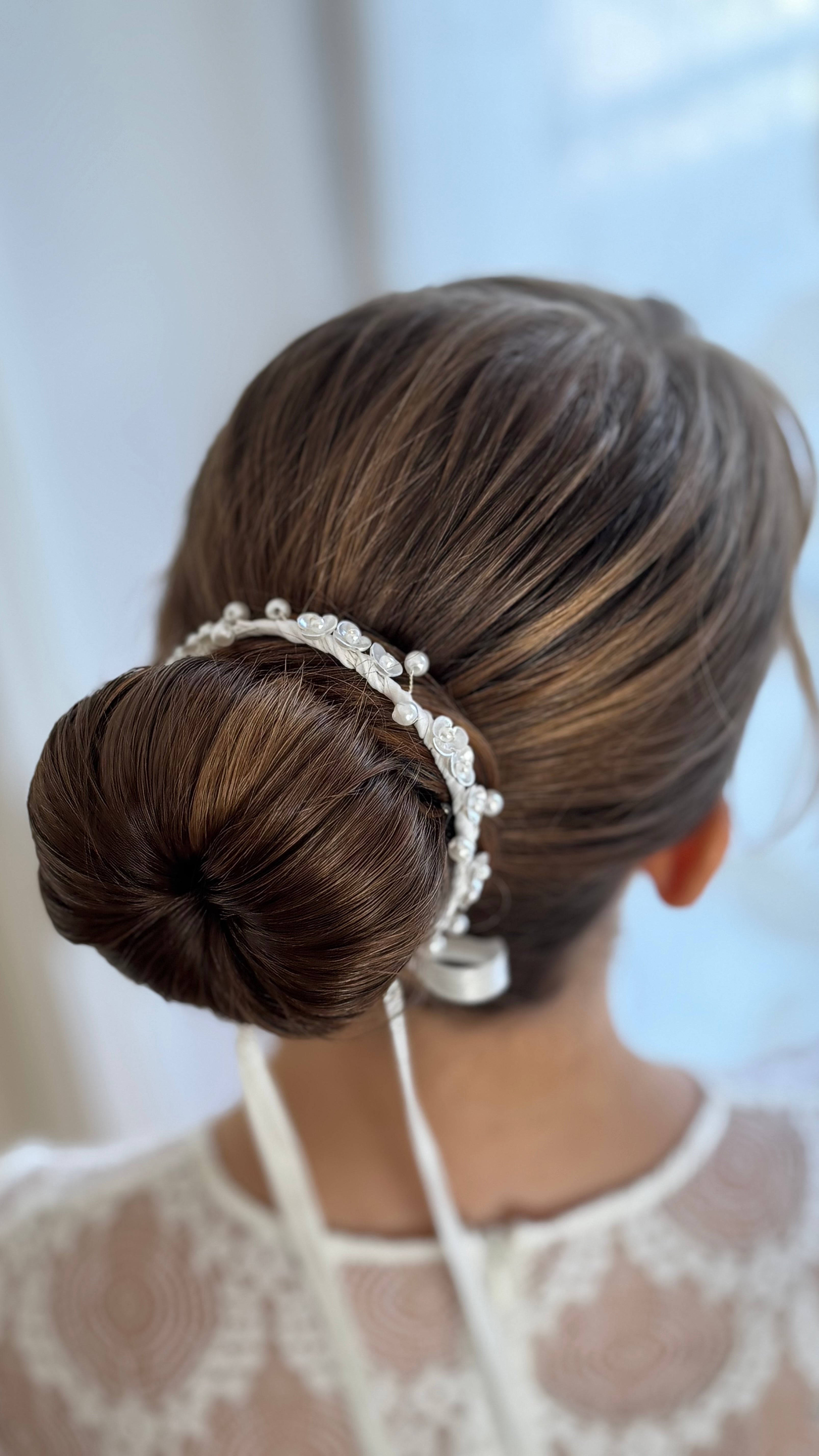 Weißes Duttband zur Kommunion, feine Perlen verarbeitet mit Blüten in weichem Material, Nahaufnahme des Designs.