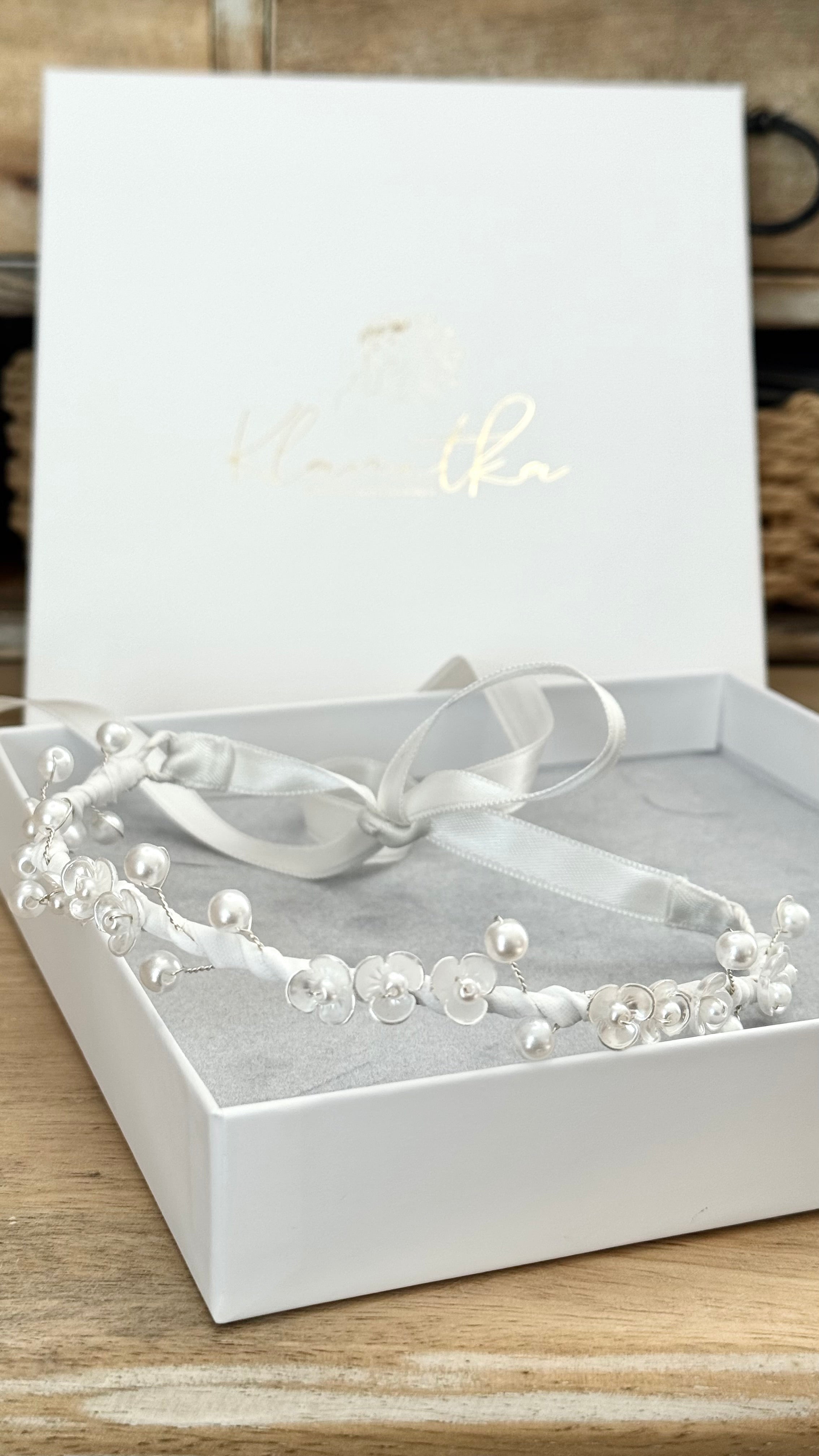 Kommunion-Haarschmuck für Mädchen, weiß, mit filigranen Perlen und Blumen, liegend präsentiert zur Detailansicht.